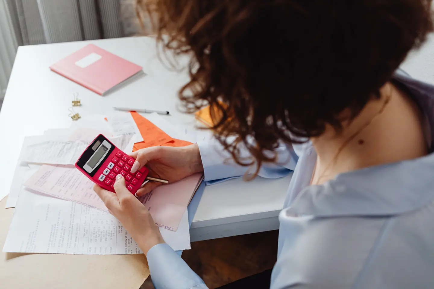 Cómo calcular el precio de productos sublimados 3 Persona calculando costes y gastos con una calculadora