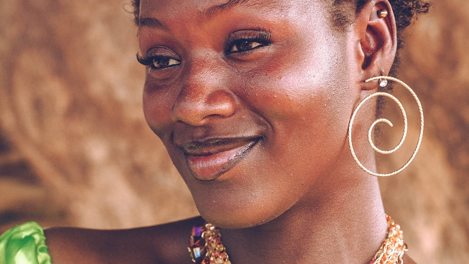 Cómo crear un catálogo de bisutería por WhatsApp paso a paso 5 Mujer sonriente luciendo pendientes y collar como cierre positivo de un catálogo de bisutería