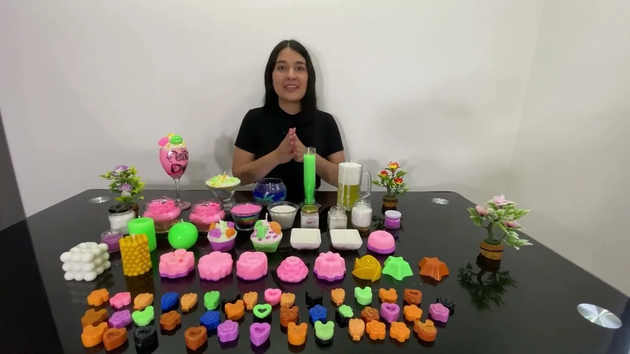 Presentación del curso de velas artesanales con una mesa de diseños y moldes terminados