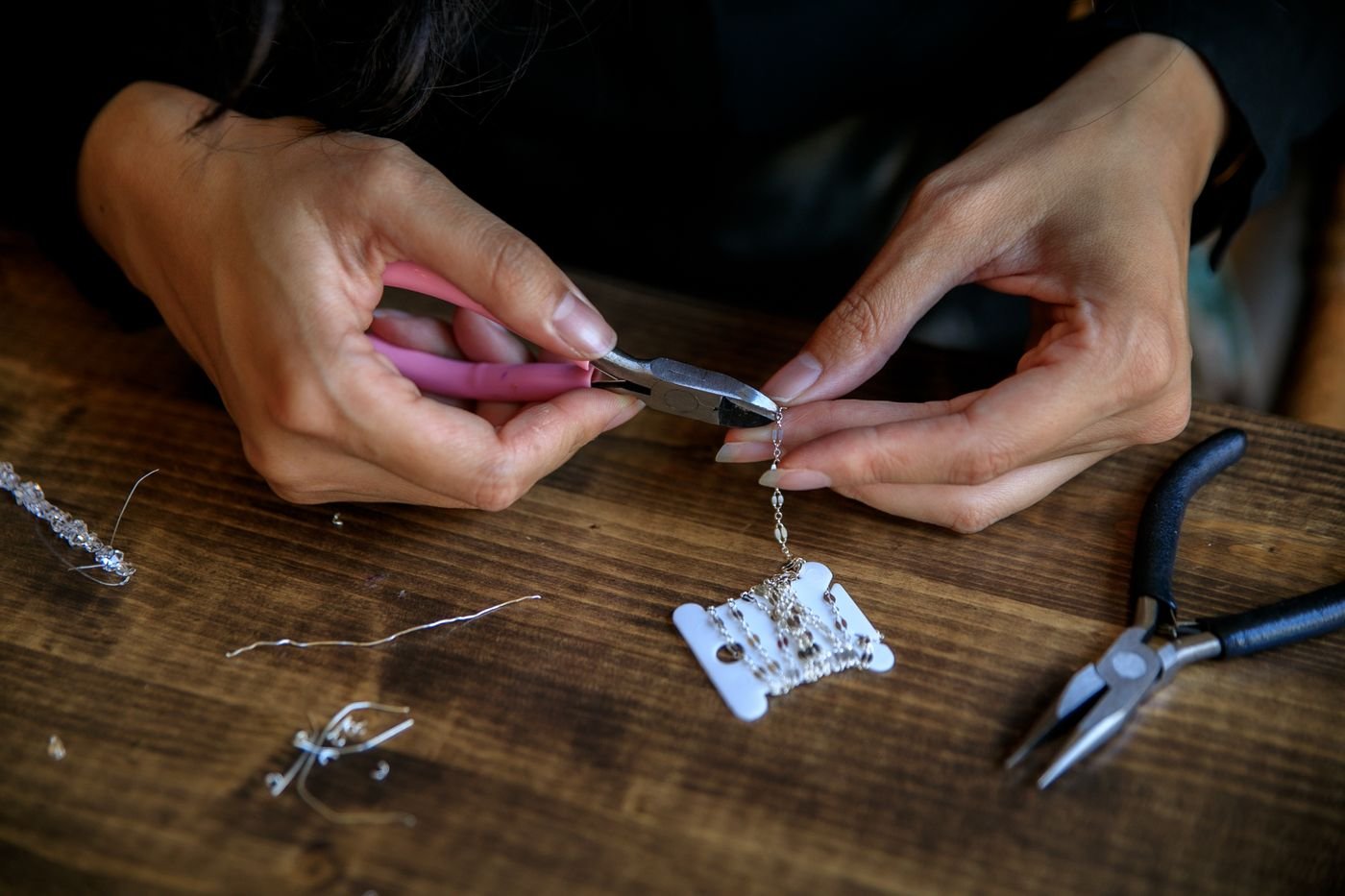 Cómo crear un catálogo de bisutería por WhatsApp paso a paso 4 Manos elaborando bisutería artesanal con herramientas y piezas pequeñas
