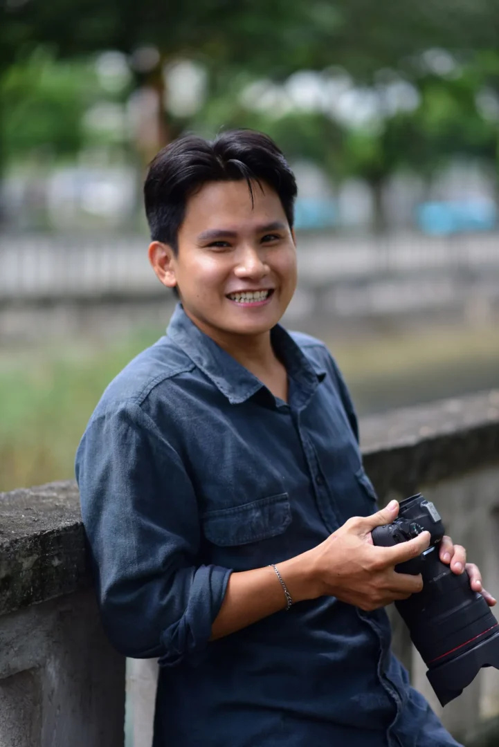Ejercicios de fotografía para principiantes: practica 7 días sin comprar más equipo 2 Ejercicios de fotografía para principiantes con un fotógrafo sonriente y una cámara al aire libre