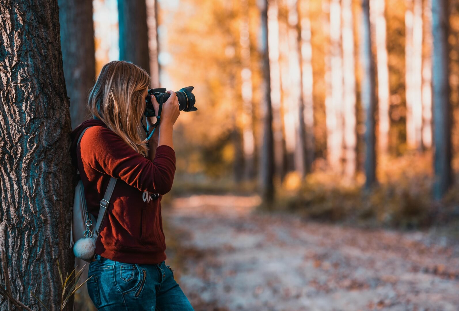 Guía completa de fotografía 2025 Salidas profesionales y futuro laboral» mujer haciendo una fotografia en un bosque