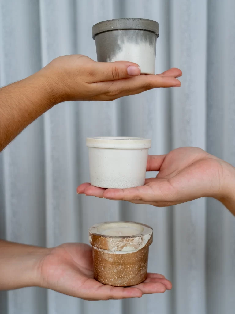 Curso de concreto decorativo: opinión sobre Piezas Decorativas en Concreto 5 Tres manos sostienen recipientes de concreto con acabados diferentes