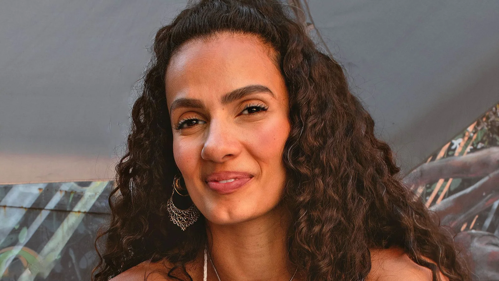 Mujer sonriente mostrando pendientes y un collar de bisutería