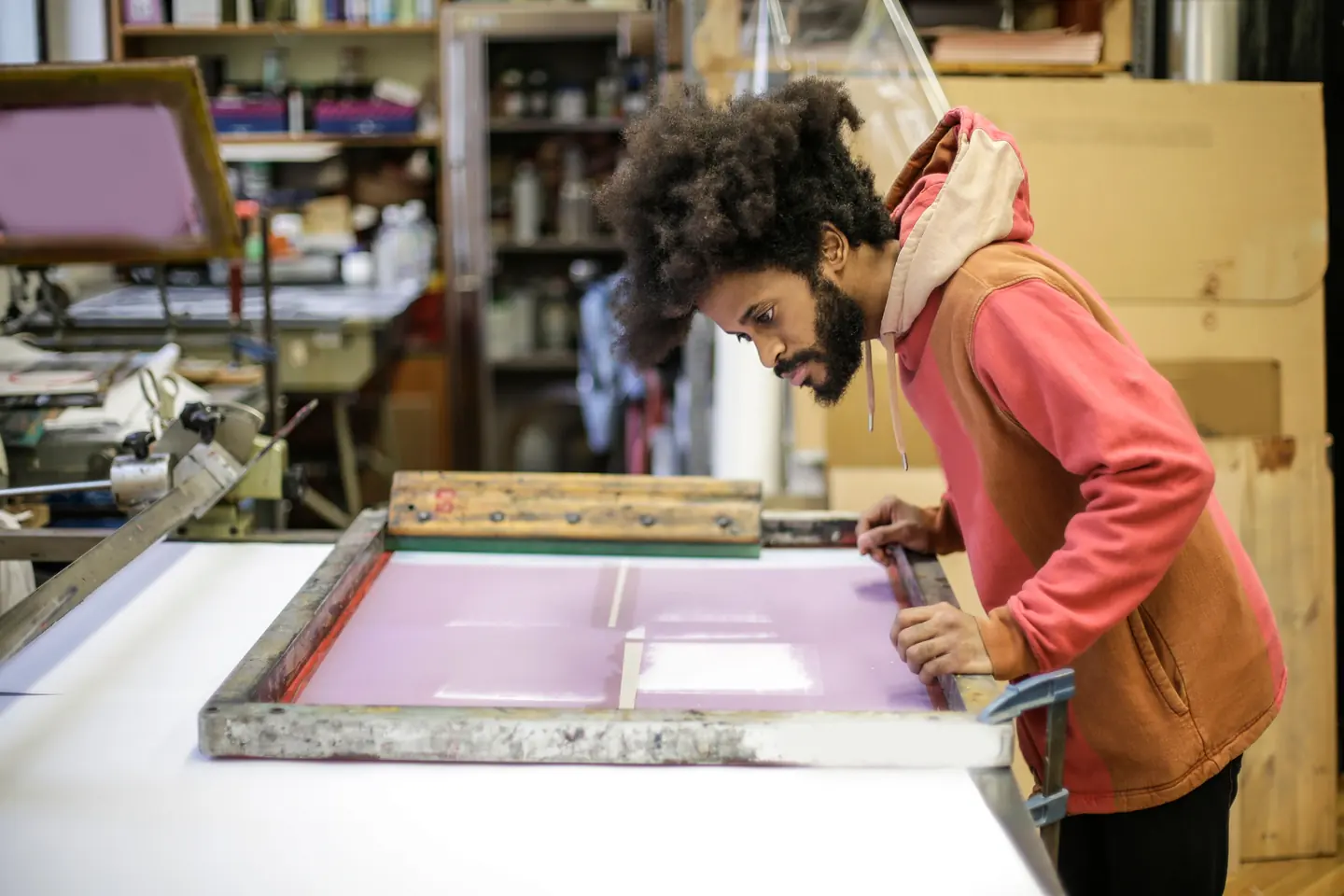 Artesano trabajando con materiales y herramientas en un pequeño taller creativo